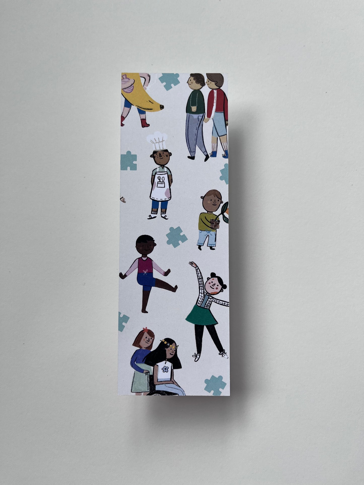 A single bookmark on a white background. The bookmark has illustrations of children of various ethnicities, cultures, disabilities and gender expressions.